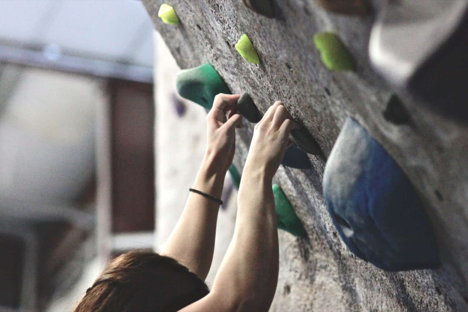 Hand reaching for a hold on the lead wall