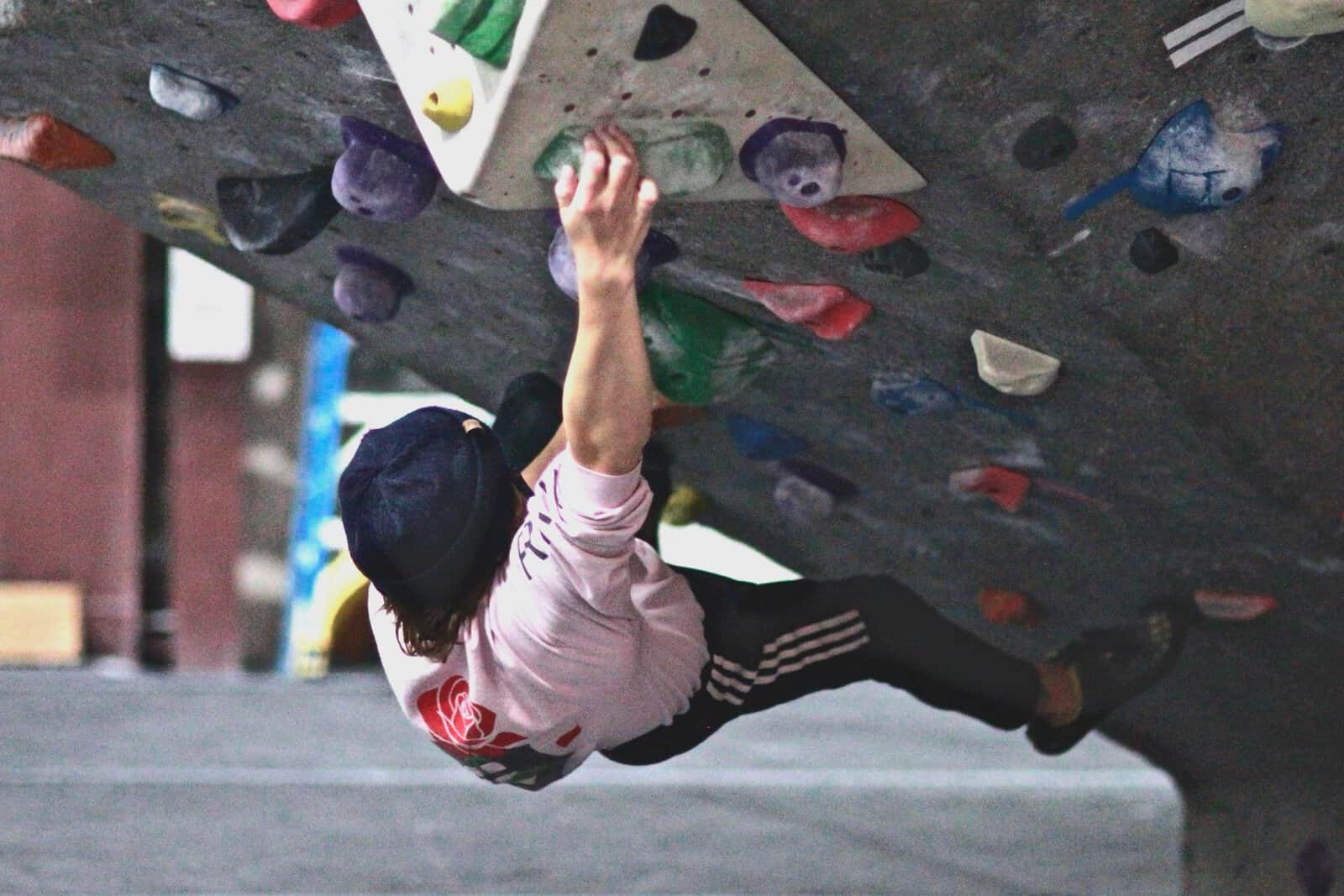 Young climber hanging from an overhang
