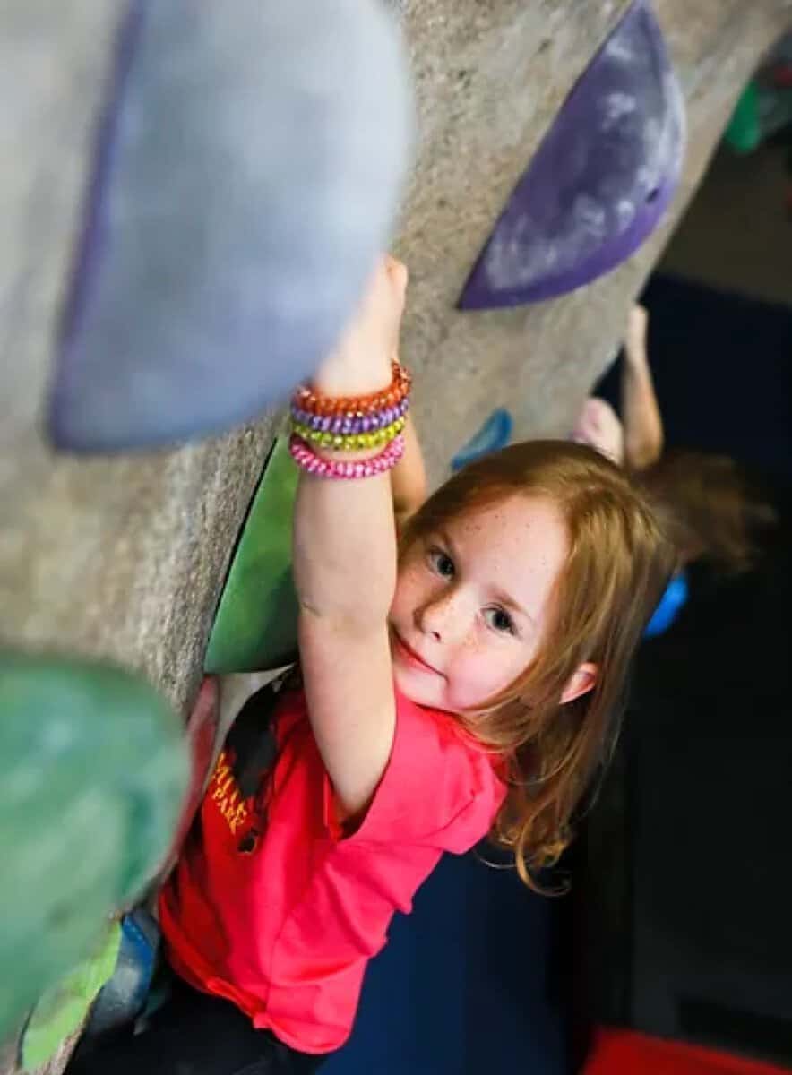 Young girl climbing on the bouldering wall